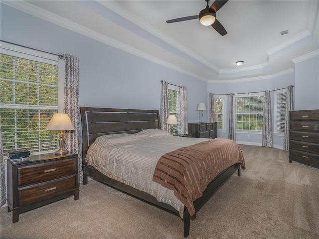 carpeted bedroom featuring crown molding, a tray ceiling, and ceiling fan