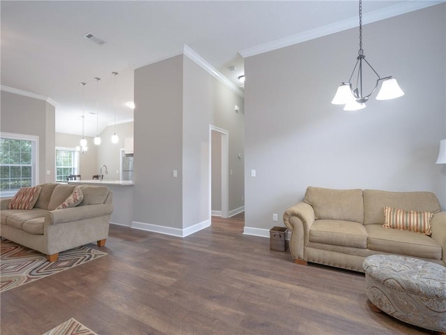 living room featuring an inviting chandelier, sink, ornamental molding, and dark hardwood / wood-style floors