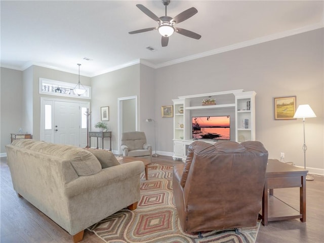 living room with hardwood / wood-style flooring, ornamental molding, and ceiling fan