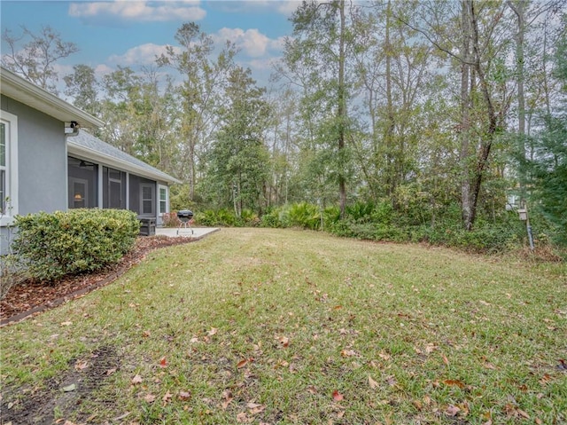 view of yard with a sunroom and a patio