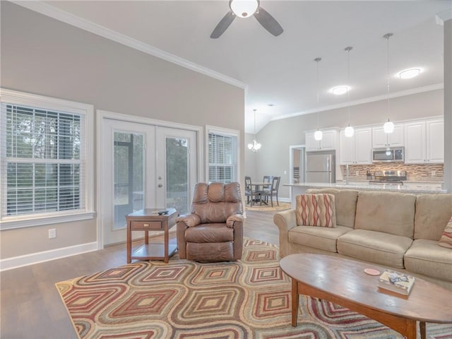 living room with ceiling fan with notable chandelier, wood-type flooring, ornamental molding, and french doors