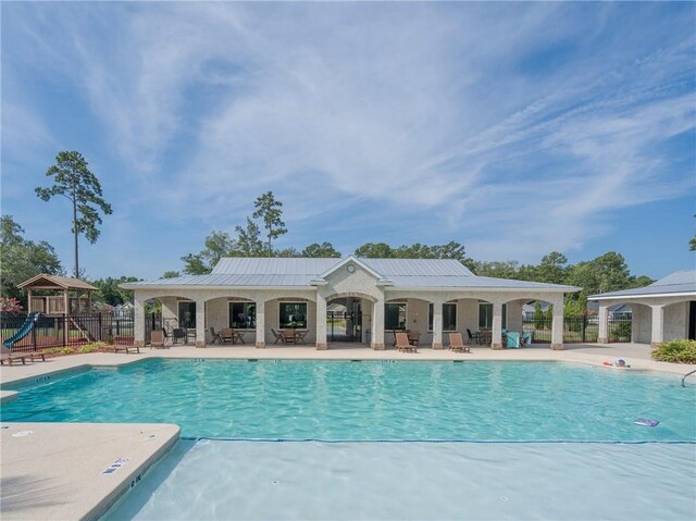 view of swimming pool with a patio area and a playground