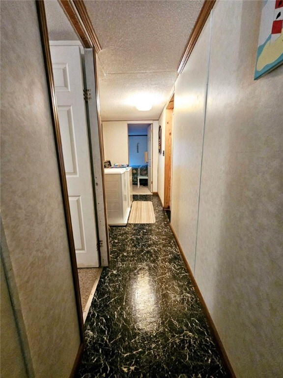 hall featuring ornamental molding and a textured ceiling