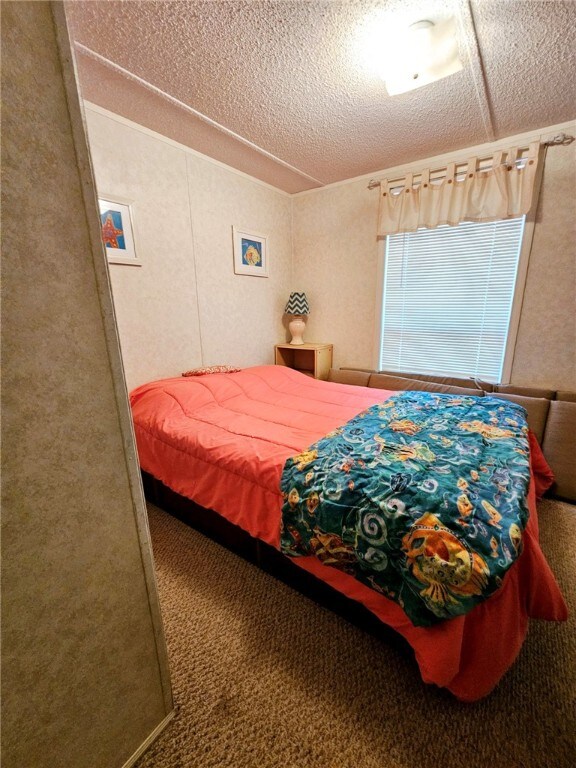 bedroom with carpet floors and a textured ceiling