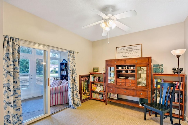 sitting room featuring light colored carpet and ceiling fan