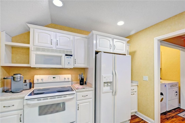 kitchen featuring dark wood-type flooring, lofted ceiling, white appliances, washing machine and dryer, and white cabinets