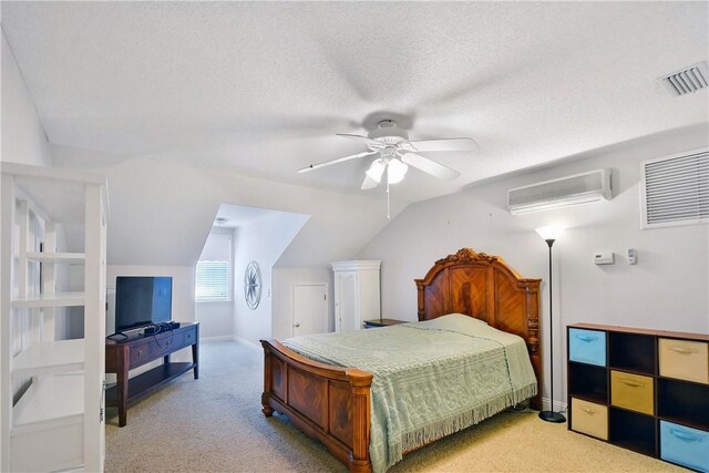 bedroom featuring ceiling fan, a textured ceiling, vaulted ceiling, light colored carpet, and an AC wall unit