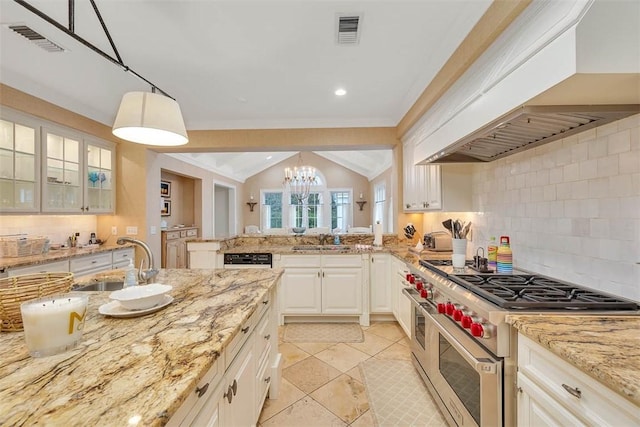 kitchen featuring visible vents, double oven range, a sink, and premium range hood