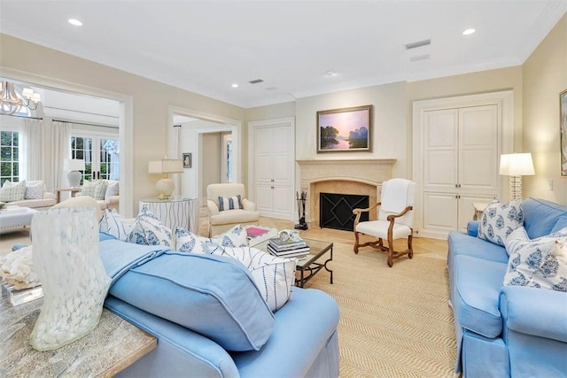 living area featuring a chandelier, recessed lighting, crown molding, and a premium fireplace