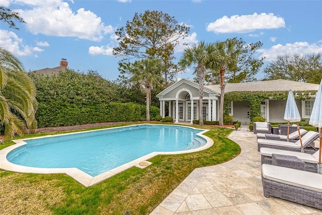 outdoor pool with a patio and french doors