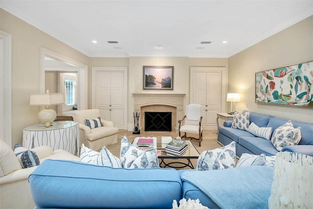 living room with crown molding, recessed lighting, visible vents, and a fireplace