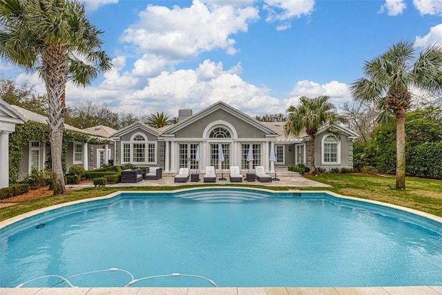 pool with french doors, a patio, and an outdoor living space