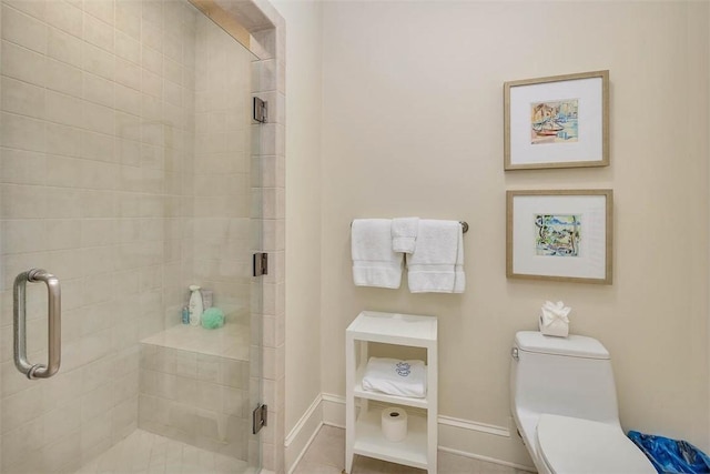 bathroom featuring a stall shower, tile patterned flooring, toilet, and baseboards