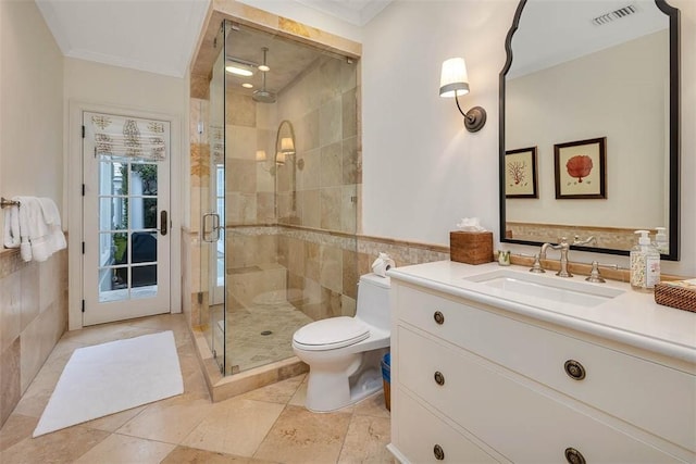 full bathroom featuring a stall shower, visible vents, toilet, ornamental molding, and tile walls