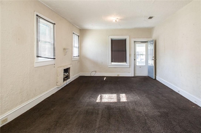 1006 Roosevelt St, Waycross, GA 31503 - unfurnished living room featuring healthy amount of natural light, carpet flooring, baseboards, a textured ceiling, and a textured wall