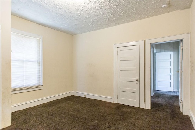 1006 Roosevelt St, Waycross, GA 31503 - unfurnished room with dark colored carpet, a textured ceiling, and baseboards