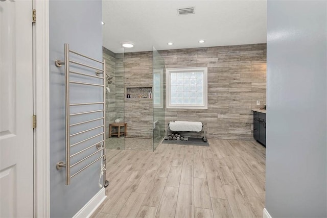 189 Harbor Pointe Dr, Brunswick, GA 31523 - bathroom with a walk in shower, vanity, radiator, wood finished floors, and recessed lighting