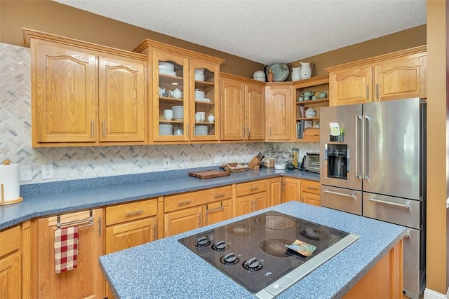 189 Harbor Pointe Dr, Brunswick, GA 31523 - kitchen with high end fridge, black electric cooktop, glass insert cabinets, open shelves, and decorative backsplash