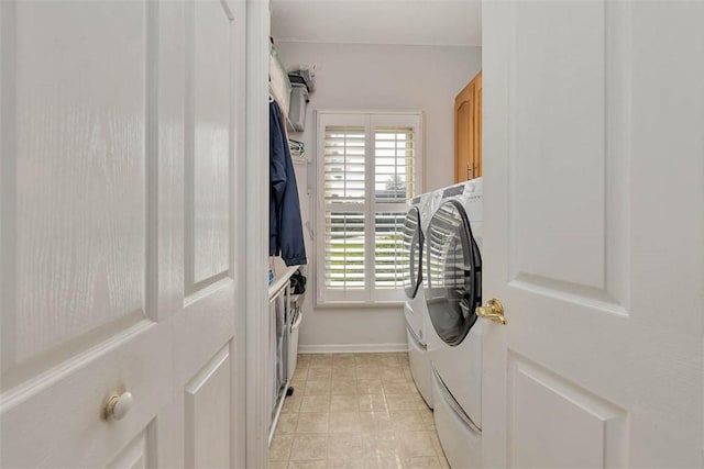 189 Harbor Pointe Dr, Brunswick, GA 31523 - laundry area featuring washer and clothes dryer, cabinet space, baseboards, and light tile patterned flooring