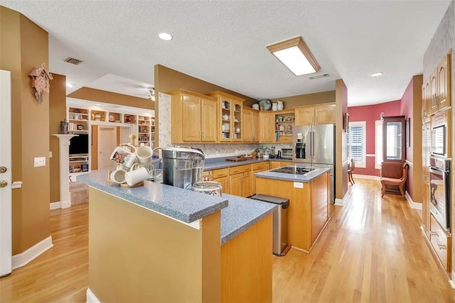 189 Harbor Pointe Dr, Brunswick, GA 31523 - kitchen with stainless steel appliances, a center island, light wood finished floors, baseboards, and glass insert cabinets