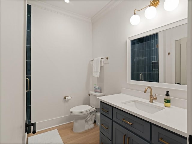 bathroom with vanity, toilet, ornamental molding, walk in shower, and wood-type flooring