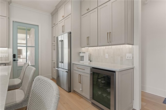 kitchen with decorative backsplash, beverage cooler, light wood-type flooring, and high quality fridge