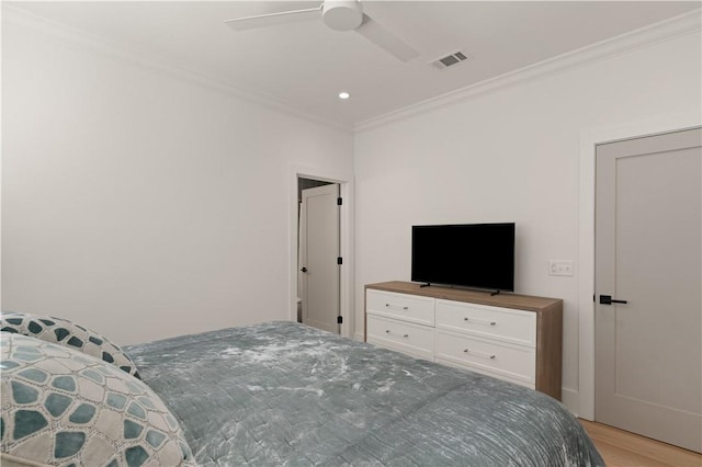 bedroom with light hardwood / wood-style flooring, ceiling fan, and ornamental molding