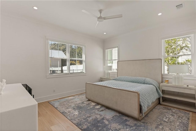 bedroom featuring light wood-type flooring, multiple windows, and ceiling fan