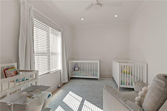 carpeted bedroom featuring ceiling fan, ornamental molding, multiple windows, and a nursery area