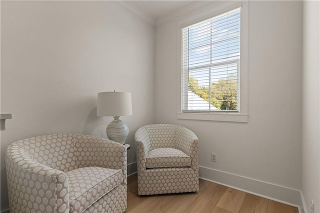 sitting room with crown molding, a wealth of natural light, and light hardwood / wood-style flooring