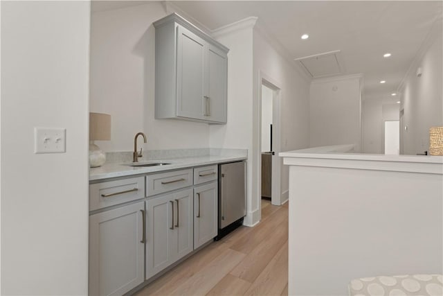 kitchen featuring stainless steel fridge, gray cabinetry, crown molding, sink, and light hardwood / wood-style flooring