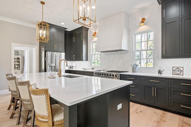 kitchen featuring sink, stainless steel appliances, a kitchen island with sink, and custom exhaust hood