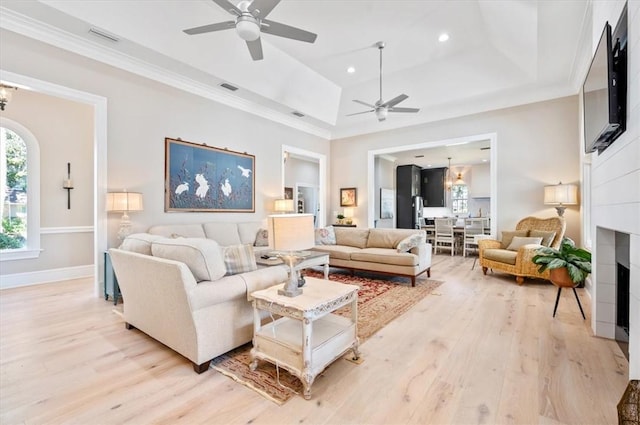 living room featuring ceiling fan, light hardwood / wood-style floors, and a raised ceiling