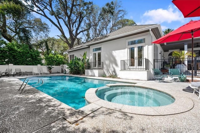 view of pool with a patio area, an in ground hot tub, and french doors