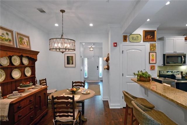 1902 Mariners Cir, Saint Simons Island, GA 31522 - dining room with crown molding, dark wood-type flooring, a chandelier, and recessed lighting