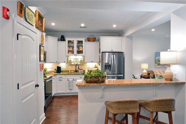 1902 Mariners Cir, Saint Simons Island, GA 31522 - kitchen with stainless steel fridge, crown molding, light stone counters, electric stove, and a sink