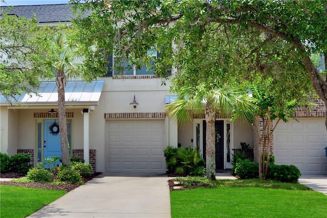 1902 Mariners Cir, Saint Simons Island, GA 31522 - view of front of house featuring a front lawn, concrete driveway, stucco siding, and an attached garage