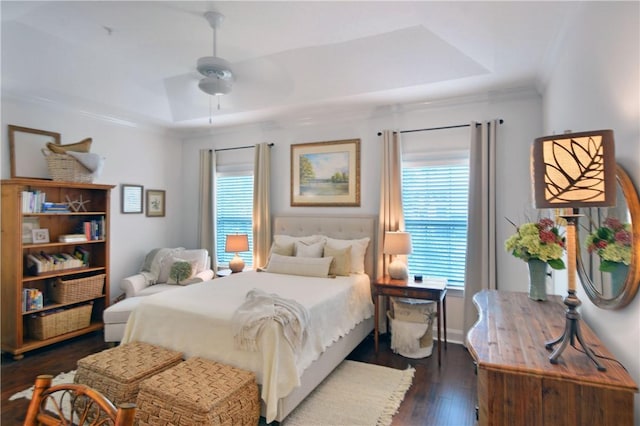1902 Mariners Cir, Saint Simons Island, GA 31522 - bedroom featuring multiple windows, a raised ceiling, dark wood-style flooring, ornamental molding, and a ceiling fan