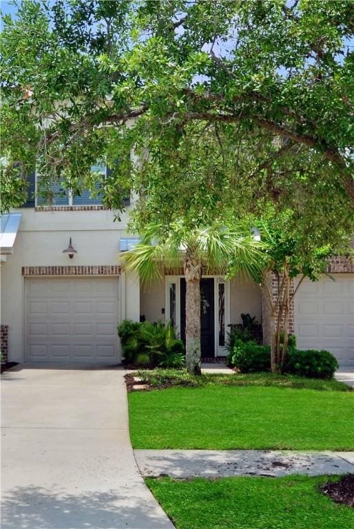 1902 Mariners Cir, Saint Simons Island, GA 31522 - view of front of house featuring a front yard, concrete driveway, and stucco siding
