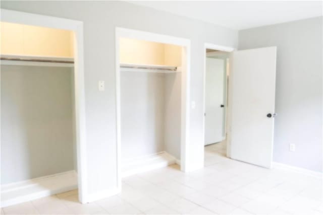 695 Lanes Bridge Rd, Jesup, GA 31545 - unfurnished bedroom featuring a closet, baseboards, and light tile patterned floors