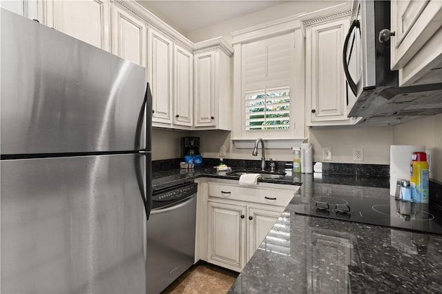 kitchen featuring white cabinets, sink, stainless steel appliances, and dark stone counters