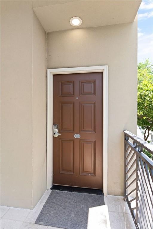 view of exterior entry with a balcony