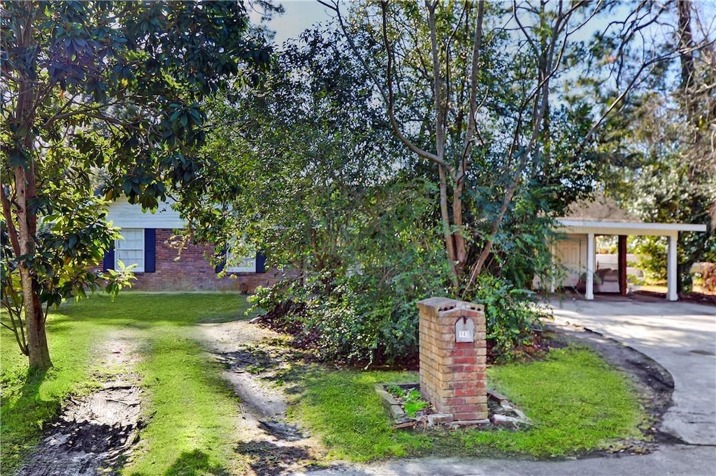view of front of house featuring concrete driveway, a front lawn, and brick siding