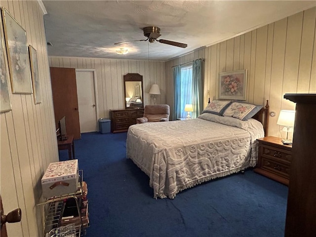 bedroom featuring carpet flooring, ceiling fan, and wood walls