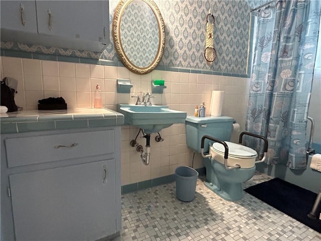 full bathroom featuring sink, shower / bath combination with curtain, toilet, and tile walls