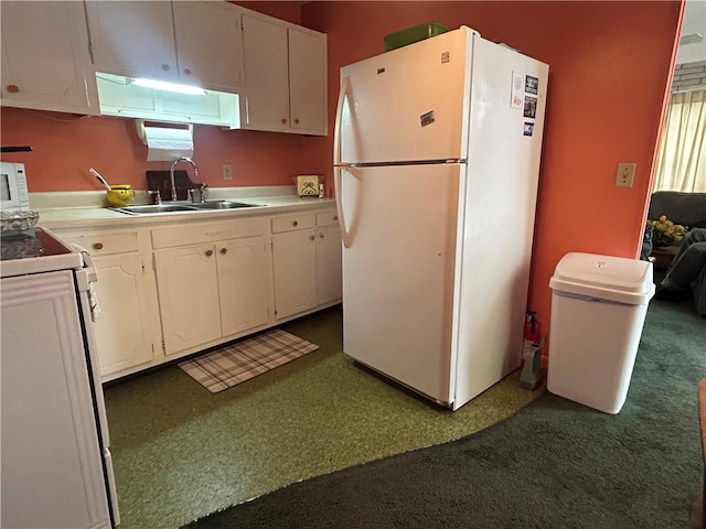 kitchen featuring white appliances, white cabinetry, and a wealth of natural light