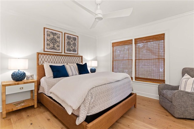 bedroom featuring light wood-type flooring, baseboards, ornamental molding, and ceiling fan