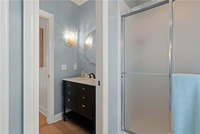 full bathroom featuring baseboards, a shower stall, vanity, and wood finished floors