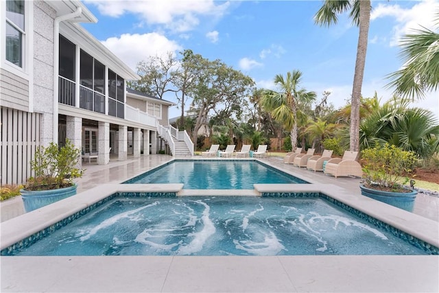 view of pool featuring stairs, a patio, and an in ground hot tub