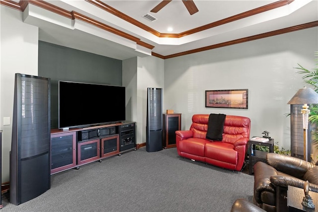 living room featuring a tray ceiling, carpet floors, ornamental molding, and ceiling fan